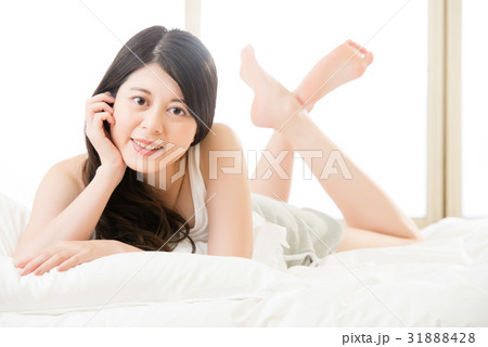 asian woman smile face to camera, lie on bed 31888428