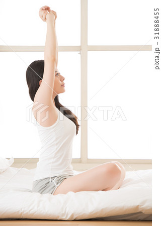 woman stretching sitting on bed in morning 31888455