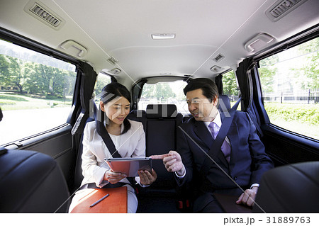ビジネス タブレット 秘書 社長 役員 車 車内 移動 打ち合わせ 会議 ミーティング ビジネスマンの写真素材 ビジネス タブレット 秘書 社長 役員 車 車内 移動 打ち合わせ 会議 ミーティング ビジネスマンの写真素材