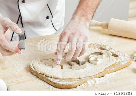 Man chef in uniform makes cookies with baking 31891803