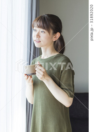 窓際でコーヒーを飲む女性 窓際でコーヒーを飲む女性 31892020