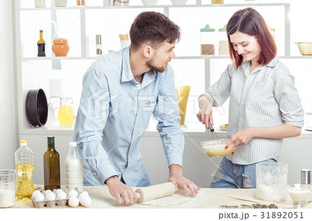 happy Couple in love kneading dough in kitchen happy Couple in love kneading dough in kitchen 31892051