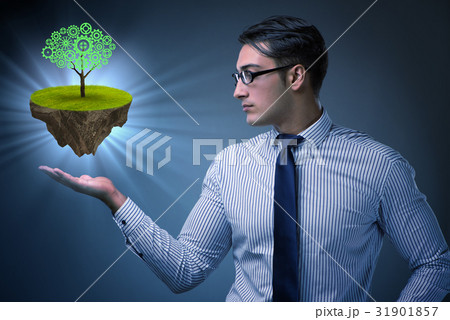Businessman holding floating island with tree 31901857