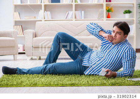 Young handsome man sitting on floor at home 31902314