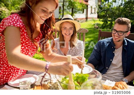 happy friends having dinner at summer garden party 31905006