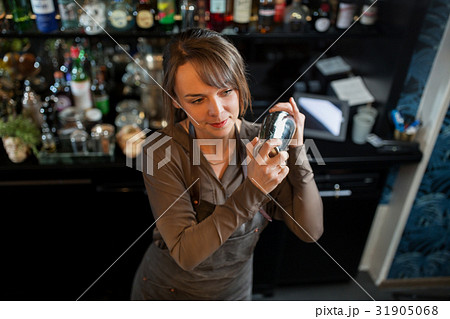 barmaid with shaker preparing cocktail at bar 31905068