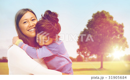 happy mother and daughter hugging outdoors happy mother and daughter hugging outdoors 31905684