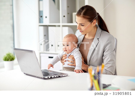 happy businesswoman with baby and laptop at office 31905801