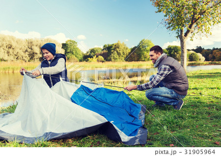 happy father and son setting up tent outdoors 31905964