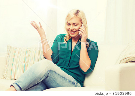 happy young woman calling on smartphone at home happy young woman calling on smartphone at home 31905996