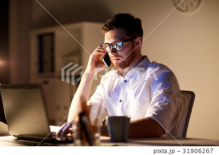 businessman calling on smartphone at night office 31906267