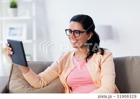 happy indian woman with tablet pc at home happy indian woman with tablet pc at home 31906329