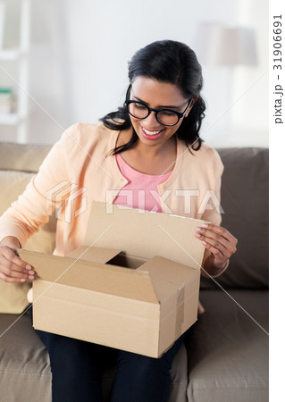 happy young indian woman with parcel box at home 31906691