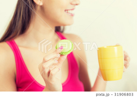 close up of happy woman or teen girl with cookie 31906803