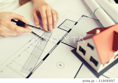 close up of hands with compass measuring blueprint close up of hands with compass measuring blueprint 31906897