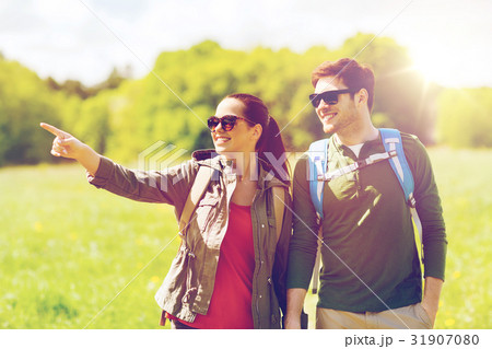 happy couple with backpacks hiking outdoors 31907080