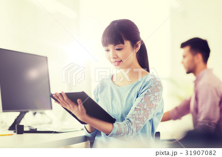 happy creative female office worker with tablet pc 31907082