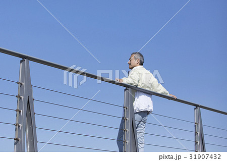 手すりにもたれる男性の写真素材