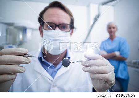 Dentist holding dental tools Dentist holding dental tools 31907958