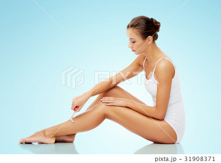 woman with safety razor shaving legs over blue 31908371