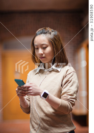 Young woman using mobile phone in corridor Young woman using mobile phone in corridor 31908590