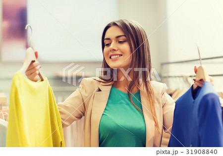 happy young woman choosing clothes in mall happy young woman choosing clothes in mall 31908840