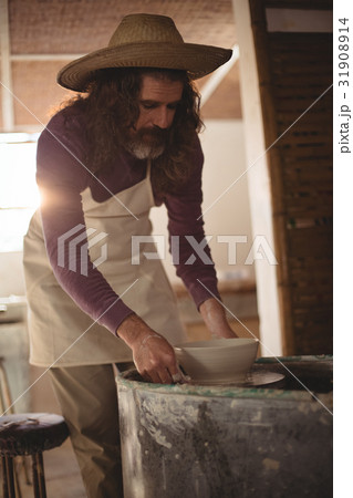 Male potter making bowl 31908914