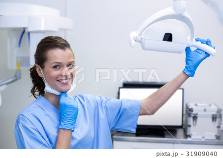 Portrait of dental assistant adjusting light 31909040