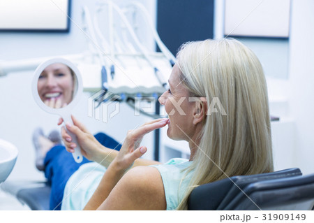 Female patient looking at mirror Female patient looking at mirror 31909149