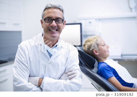 Portrait of smiling dentist standing with arms crossed Portrait of smiling dentist standing with arms crossed 31909192