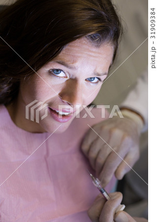 Dentist injecting female patient 31909384