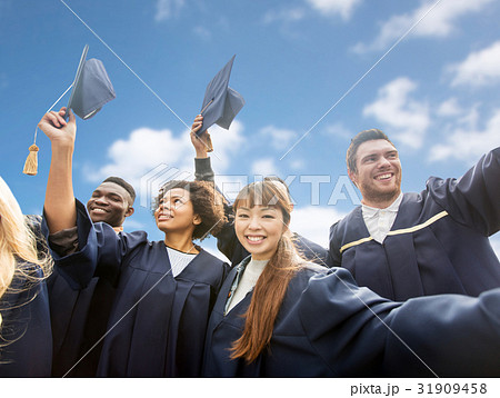 happy bachelors waving mortar boards over sky happy bachelors waving mortar boards over sky 31909458