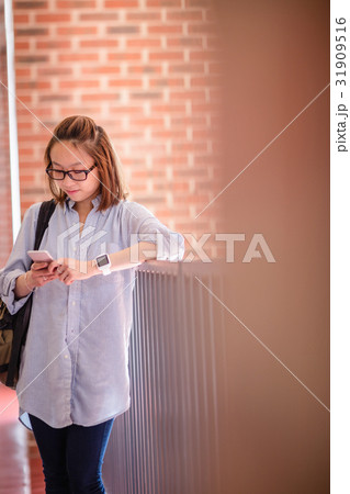 Young woman using mobile phone in corridor 31909516
