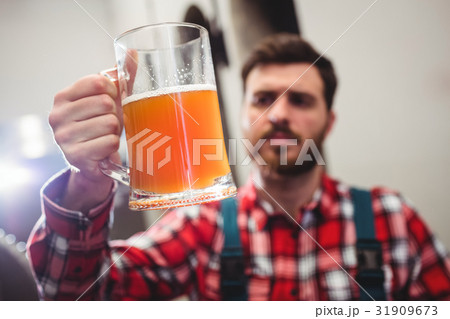 Manufacturer holding beer in jug Manufacturer holding beer in jug 31909673