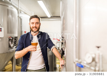 man drinking and testing craft beer at brewery 31909881