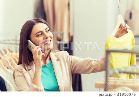 woman calling on smartphone at clothing store woman calling on smartphone at clothing store 31910079