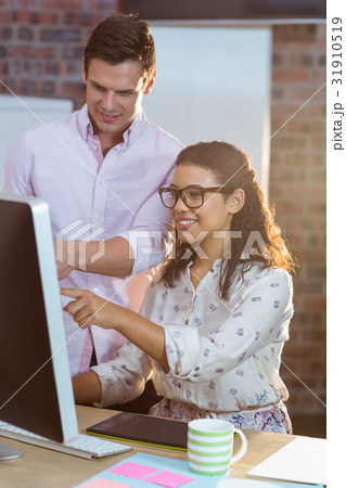 Businesswoman interacting with coworker while working on computer 31910519