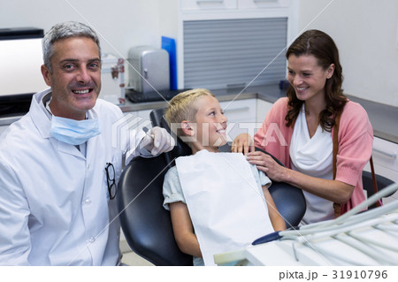 Mother and son talking while dentist examining 31910796