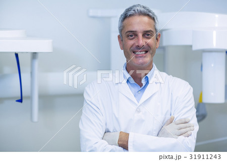 Smiling dentist standing in dental clinic Smiling dentist standing in dental clinic 31911243