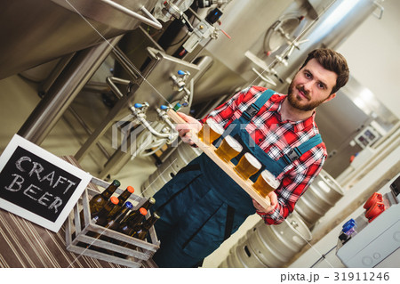 Portrait of manufacturer holding beer samples 31911246