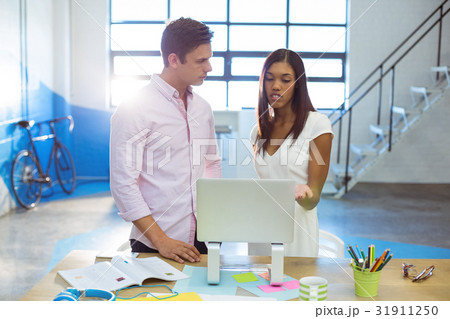 Business people discussing over laptop Business people discussing over laptop 31911250