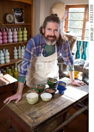 Portrait of male potter standing at table 31911306