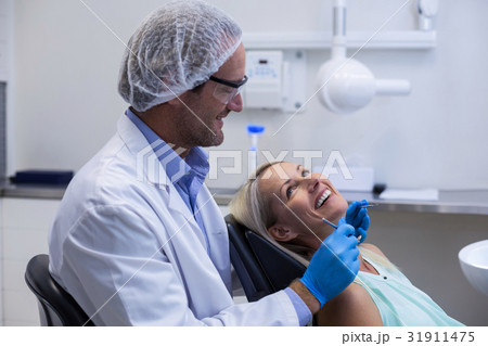 Male dentist interacting with female patient Male dentist interacting with female patient 31911475