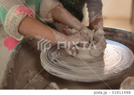 Girls making pot in pottery workshop 31911498