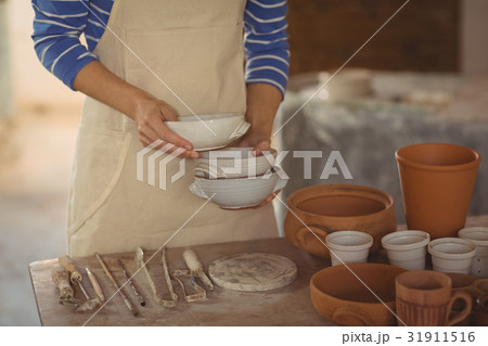 Mid section of potter holding bowl 31911516