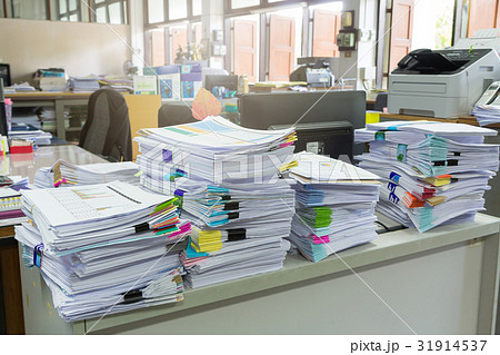 Pile of unfinished documents on office desk 31914537
