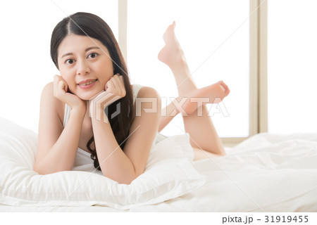 Asian young woman lying on bed comfortably Asian young woman lying on bed comfortably 31919455