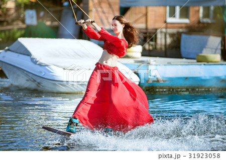 Woman in red on a wakeboard. 31923058