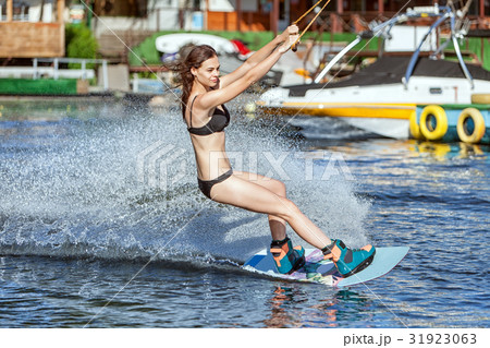 Woman on the board slides on the water. 31923063