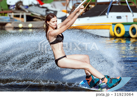 Woman in a swimsuit surfs. 31923064